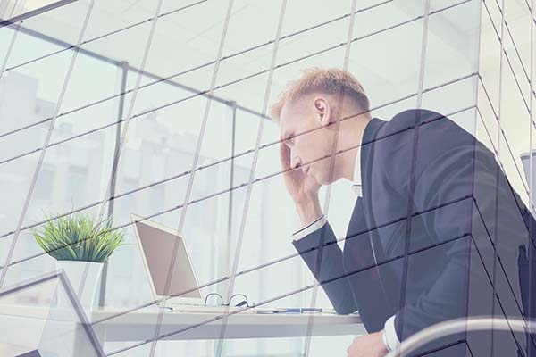 man sitting at laptop experiencing workplace burnout